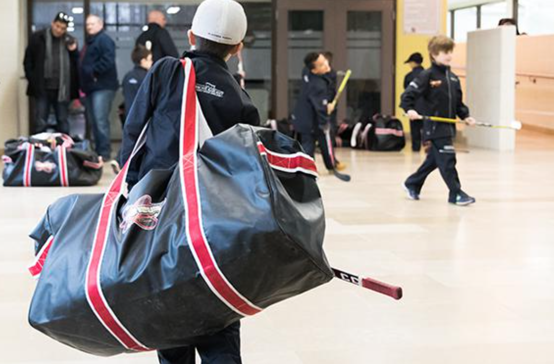Child at a GTA hockey rink, equipment in frame
